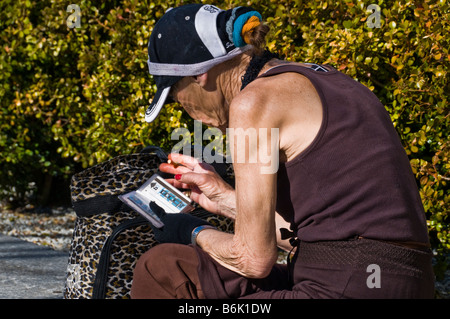 Senzatetto donna seduta sulla panchina nel parco della città di San Francisco CA USA California Foto Stock