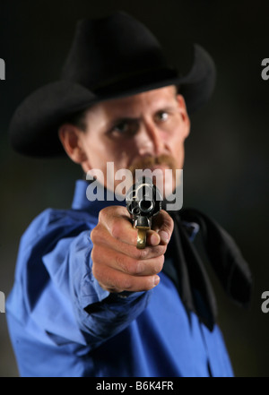 Cowboy minaccioso puntando revolver pistola alla fotocamera Foto Stock