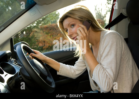 Donna che parla al telefono in auto Foto Stock