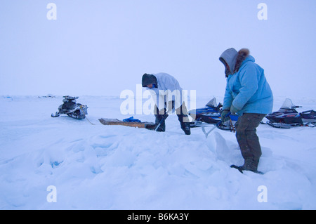 Inupiaq sussistenza whalers rompere il ghiaccio del ghiacciaio con assi di prelevamento per fondere per acqua potabile durante la primavera stagione di caccia alle balene mare Chukchi Foto Stock