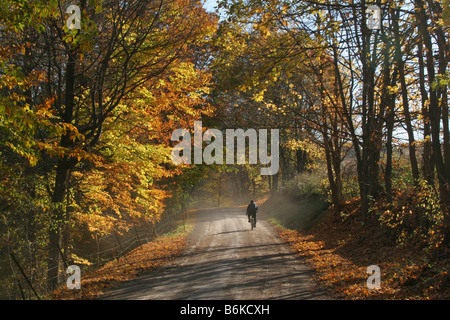 Strada d'autunno uomo Amish in bicicletta il Paese Amish in Ohio centrale. Foto Stock