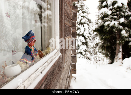 Bambola in Lappone tradizionale / Sami costume in una finestra di una capanna in legno, Kuusamo, Finlandia Foto Stock