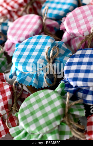 Close-up di barattoli di chutney coperto abbastanza tessuto gingham legato con la stringa rustico. Per essere dato come doni. Foto Stock