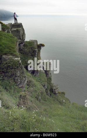 Un viandante si fermò sulla molto alte scogliere a Lynmouth in Devon Foto Stock