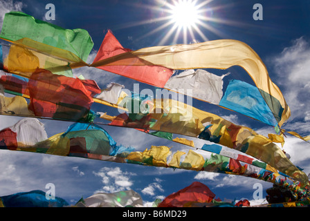 Bandiere di preghiera sbattimenti nel sole di mezzogiorno sulla cima di un affioramento al lago Namtso, Tibet Foto Stock