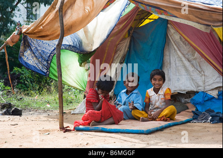 Felice povero indiano bambini seduti al di fuori della loro tenda home. Andhra Pradesh, India Foto Stock