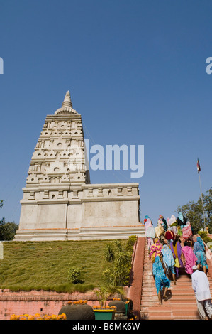 Un gruppo di pellegrini in cammino in alto su una scalinata, tempio di Mahabodhi, Bodhgaya,, Gaya, Bihar, in India Foto Stock