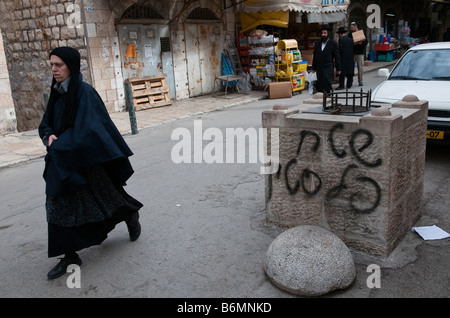 Israele Gerusalemme Mea Shearim vicinato donna in neri passa da un cartello che diceva la palestina terra Foto Stock