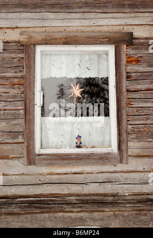 Bambola in tradizionale costume lappone nella finestra di una capanna in legno, Kuusamo, Finlandia Foto Stock
