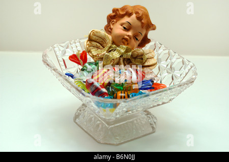 Close-up della caramella in vetro e ceramica per la testa di un cherubino a una chiara piatto di vetro utilizzati come una decorazione di Natale Foto Stock