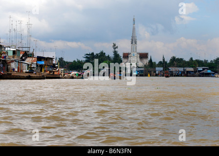 Il fiume, la Chiesa cattolica e la città di Cai Be, il Delta del Mekong, Vietnam Foto Stock