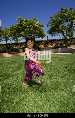 Ragazza ispanica in esecuzione sull'erba Foto Stock