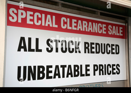 Segno su tutta una vetrina di un high street a Belfast Regno Unito tutte le scorte ridotti prezzi imbattibili offerte vendita di liquidazione Foto Stock