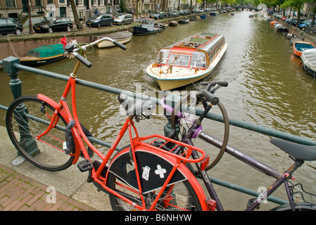 Amsterdam Bike bloccato a ponte con gita in barca di crociera nel canale Prinsengracht Foto Stock