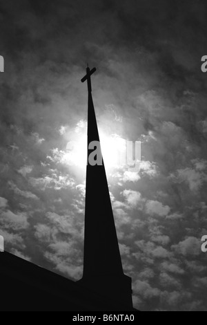 Campanile silhouette contro un soleggiato drammaticamente cielo nuvoloso. Foto Stock