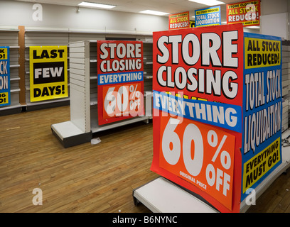 Prezzi di magazzino ridotte segni di liquidazione con gli scaffali vuoti in Woolworths shop chiusura REGNO UNITO Foto Stock