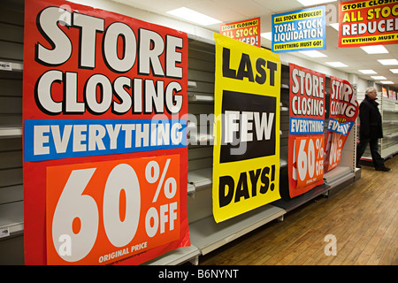 Prezzi di magazzino ridotte segni di liquidazione con gli scaffali vuoti in Woolworths shop chiusura REGNO UNITO Foto Stock