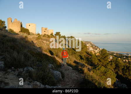 Escursionista e mulini a vento su La Plana, Javea / Xabia, Provincia di Alicante, Comunidad Valenciana, Spagna Foto Stock