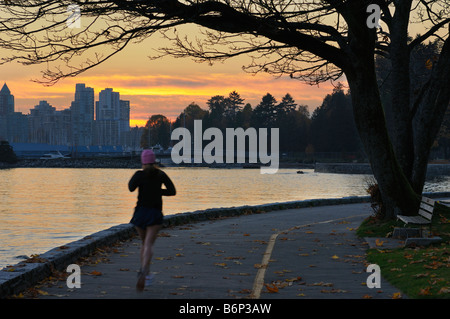 Pareggiatore femmina sul Seawall in Stanley Park a Vancouver dopo il tramonto Foto Stock