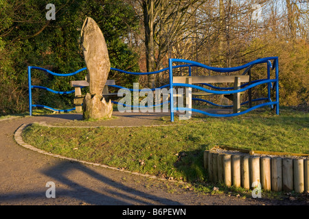 Scultura di pesce e area con posti a sedere sul fiume Mersey piede e pista ciclabile nei pressi di Parrs Wood, Manchester, Regno Unito Foto Stock