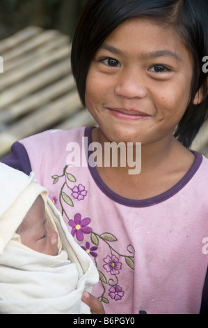 Karen rifugiati birmani in Umpian camp in Thailandia salvaguarda il neonato sorella Foto Stock