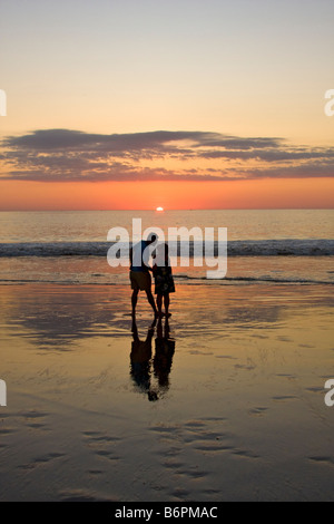 Amare giovane baci mentre godendo la spiaggia al tramonto su Flamingo Beach in Costa Rica Foto Stock