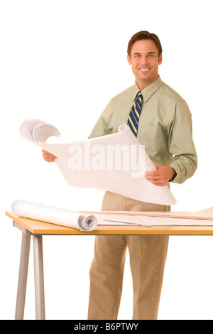 Arcitect permanente al tavolo da disegno azienda blueprints Foto Stock