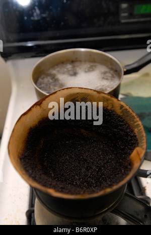 Un caffè filtro pieno di caffè usato motivi siede su un fornello in New York Foto Stock