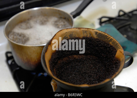 Un caffè filtro pieno di caffè usato motivi siede su un fornello in New York Foto Stock