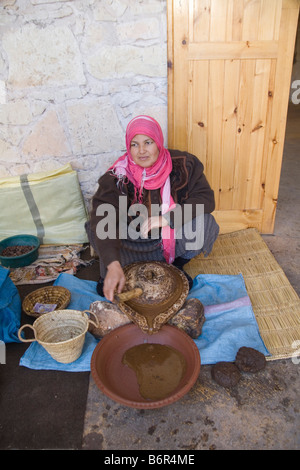 Il Marocco in Nord Africa dicembre donna marocchina macinare la mandorla noccioli di Argan alberi da frutto per produrre pasta spessa femmina co-operativa Foto Stock