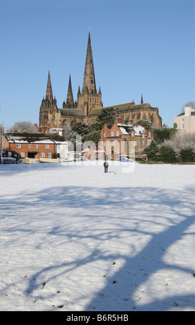 Lichfield Cathedral da Stowe campi con uomo a camminare il suo cane Lichfield Staffordshire Inghilterra Foto Stock