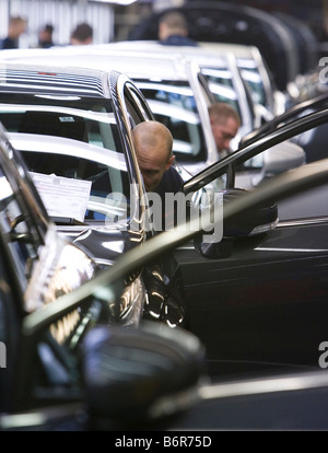 I lavoratori in casa Toyota il montaggio finale della linea di produzione fare un finale di qualità Controllo di conferma di una Toyota Avensis auto Foto Stock