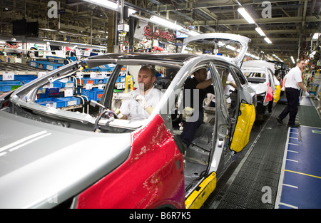 I lavoratori in casa Toyota il montaggio finale della linea di produzione le parti di accoppiamento all'interno di una Toyota Avensis auto Foto Stock