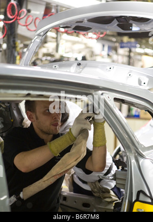 I lavoratori in casa Toyota il montaggio finale della linea di produzione le parti di accoppiamento all'interno di una Toyota Avensis auto Foto Stock