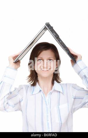 Sorridente giovane donna notebook tenuta sopra la testa Foto Stock