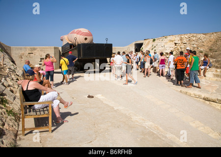I turisti in piedi accanto al Armstrong 100 ton pistola, Forte Rinella, Kalkara, Malta Foto Stock