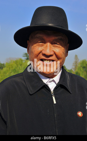 Il vecchio uomo cinese a Pechino con un perno comunista Foto Stock