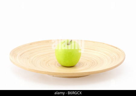 Uno apple nel centro del piatto in legno Foto Stock