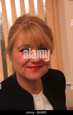 Un colpo di testa una foto di un midle invecchiato donna contro orange ciechi della finestra Foto Stock