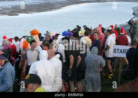 I concorrenti nell'annuale Mad Maldon gara di fango raccogliere all'inizio. Fiume Blackwater, Essex, Regno Unito Foto Stock