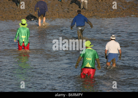 I concorrenti nell'annuale Mad Maldon gara di fango. Fiume Blackwater, Essex, Regno Unito Foto Stock