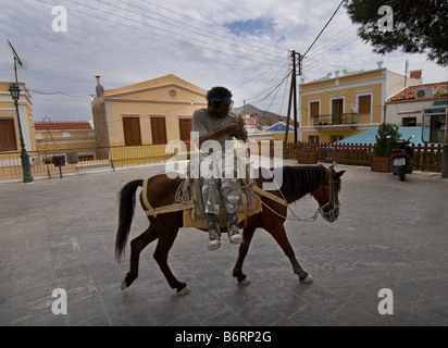 Workman su donkey di ritorno da una giornata di lavoro sull'isola greca di Symi Foto Stock