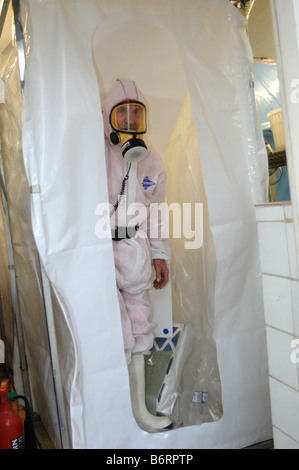 Uomo vestito in pieno gli indumenti di protezione per lavorare in un ambiente sicuro per rimuovere amianto Exeter Foto Stock