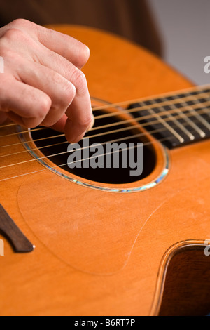 Chitarra acustica player fingerpicking la messa a fuoco a portata di mano Foto Stock