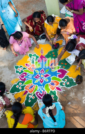 Indian ragazze adolescenti facendo una rangoli sankranthi design festival su una strada rurale. Andhra Pradesh, India Foto Stock