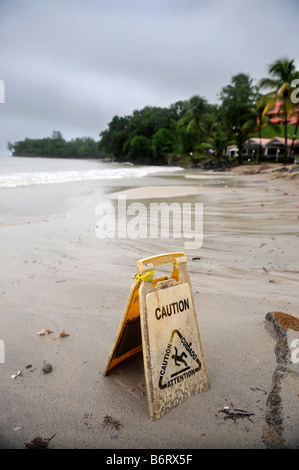 Un segnale di avvertimento su una spiaggia deserta durante una tempesta di pioggia in una vacanza ai Caraibi RESORT Foto Stock