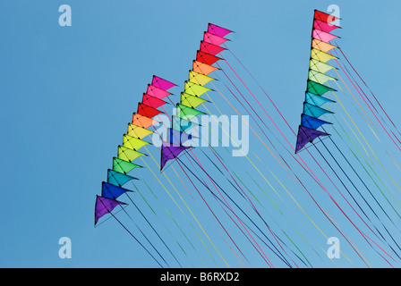 Tre pile di 12 stunt kites in arcobaleno di colori su un cielo blu sullo sfondo Foto Stock