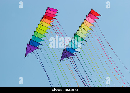 Due pile di 12 stunt kites in arcobaleno di colori su un cielo blu sullo sfondo Foto Stock