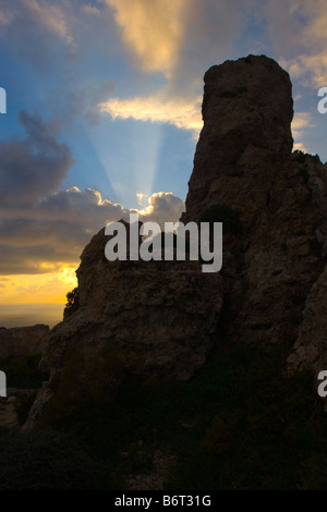 Tramonto dietro la formazione di roccia Foto Stock