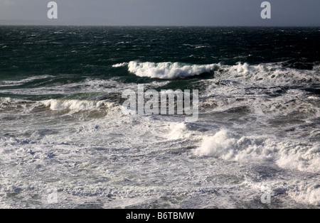 Onde che si infrangono sulla spiaggia rocciosa Foto Stock